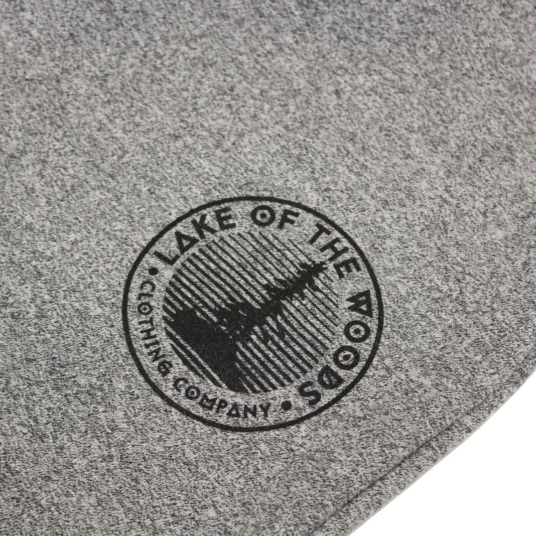 A circular outline with the text Lake of the Woods Clothing Company curved around the circle with a tree silhouette on the interior.