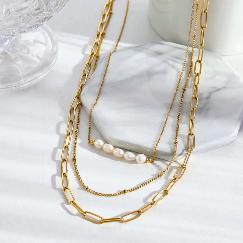 Hackney jewelry featuring 3-layer multi chain gold necklaces with natural pearls.