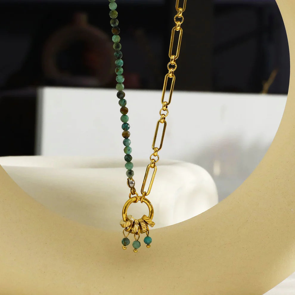 Hackney jewelry featuring a turquoise natural sone charm pendant on gold necklace.