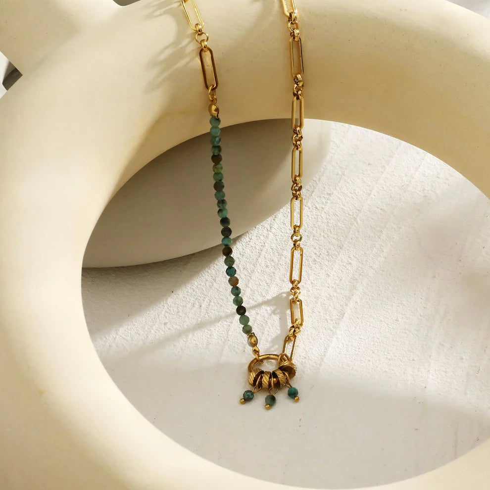 Hackney jewelry featuring a turquoise natural sone charm pendant on gold necklace.