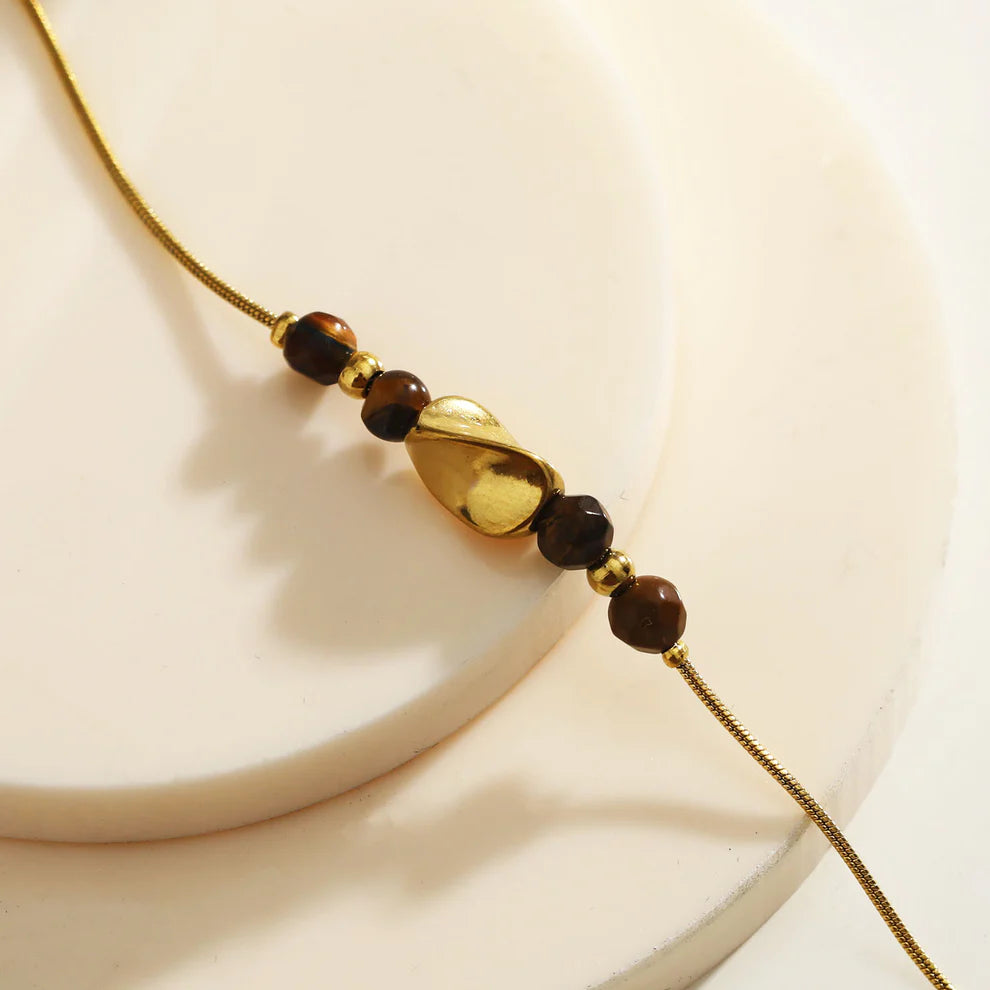 Hackney jewelry featuring a snake skin textured bracelet with gold tiger eye stone charms.