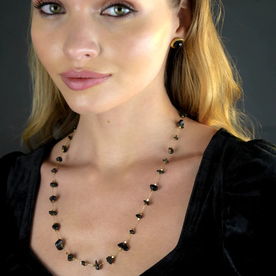 Hackney jewelry featuring a gold necklace with mini beads and natural black stones.