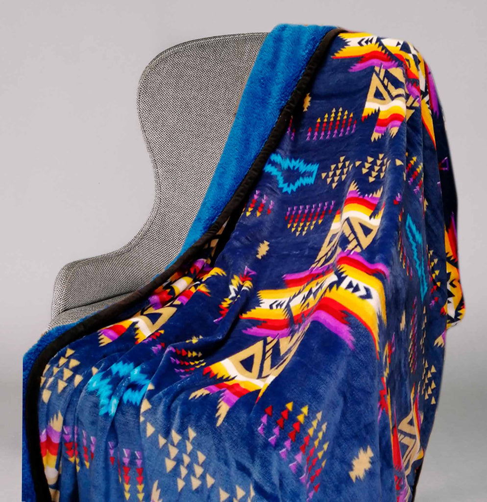 Royal blue fleece throw blanket with traditional native designs.