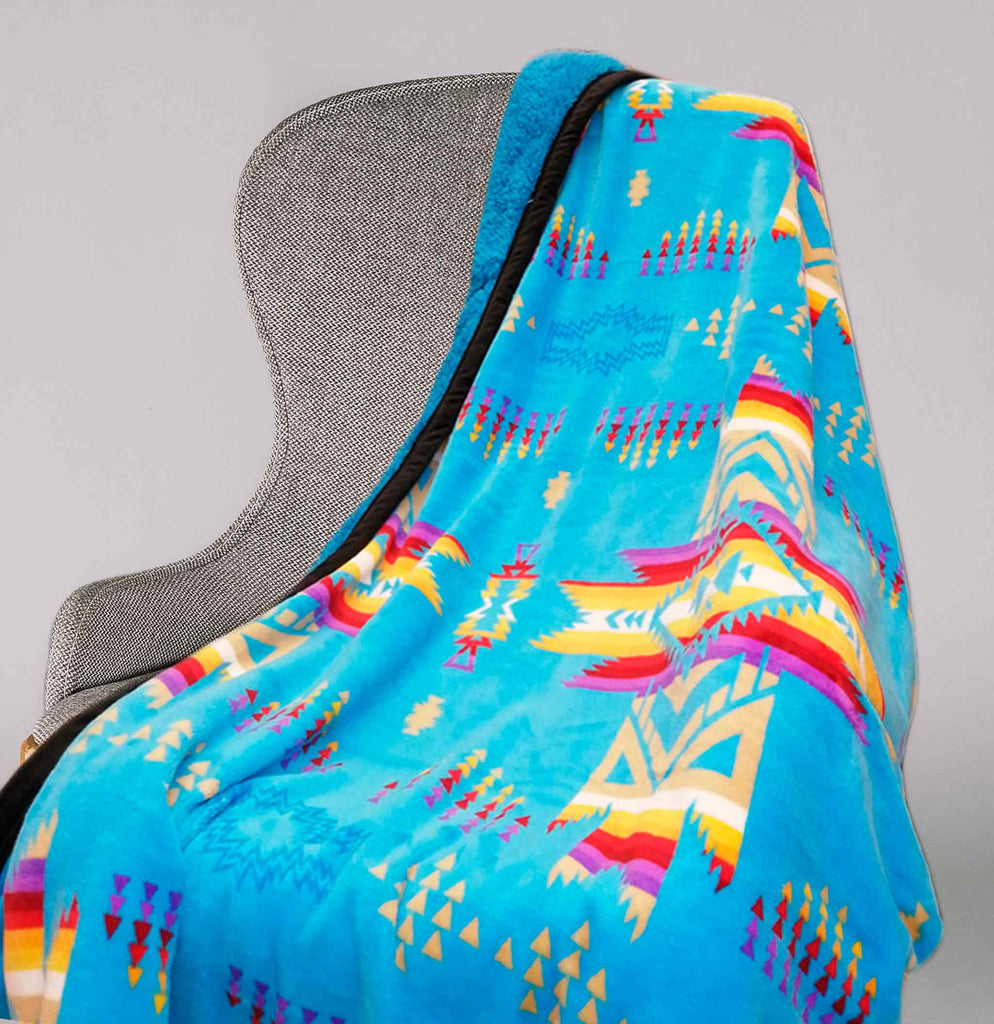 Turquoise fleece throw blanket with traditional native designs.