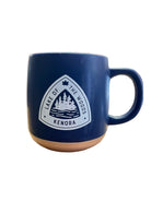 Navy blue mug with a white logo featuring trees and text on a white background