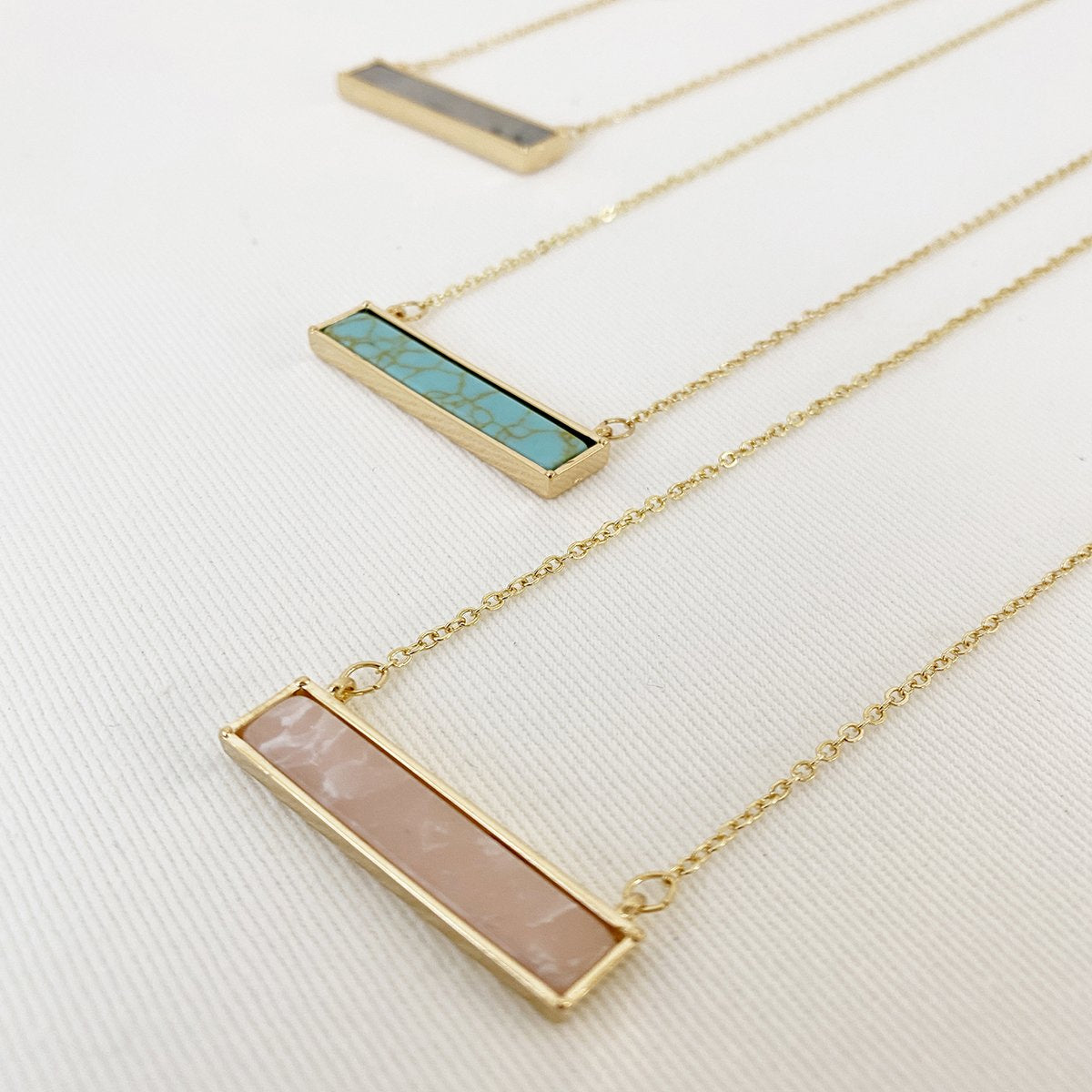 Caracol jewelry featuring a delicate chain necklace with stone pendant