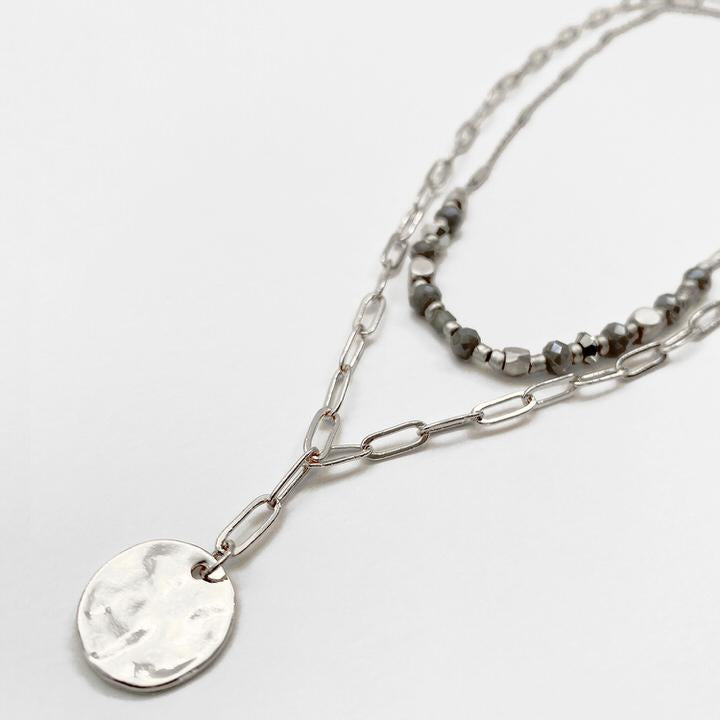 Caracol jewelry featuring a double metallic chain necklace with glass beads