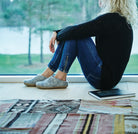 Women sitting looking out window wearing felted wool slippers with leathersole