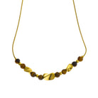 Hackney jewelry featuring a snake skin textured chain necklace with gold and tiger eye stone charms. 