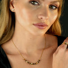 Hackney jewelry featuring a snake skin textured chain necklace with gold and tiger eye stone charms. 