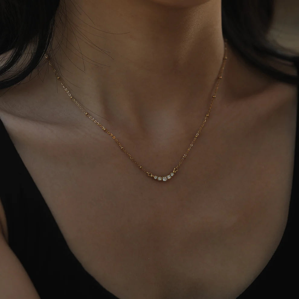 Hackney jewelry featuring a gold necklace with delicate beaded chain and gemstone charm