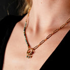 Hackney jewelry featuring a turquoise natural sone charm pendant on gold necklace.
