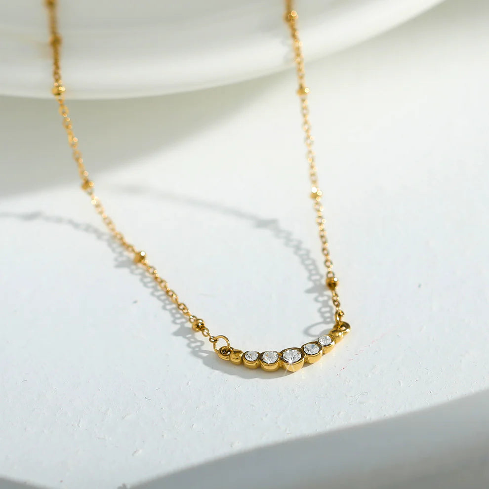 Hackney jewelry featuring a gold necklace with delicate beaded chain and gemstone charm