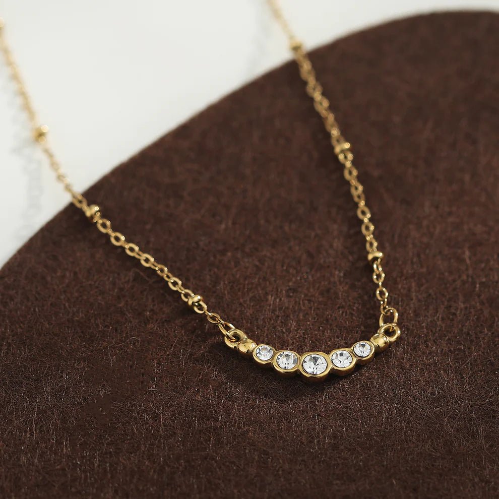 Hackney jewelry featuring a gold necklace with delicate beaded chain and gemstone charm