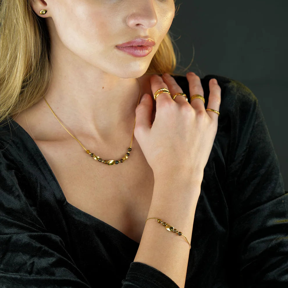 Hackney jewelry featuring a snake skin textured bracelet with gold tiger eye stone charms. 