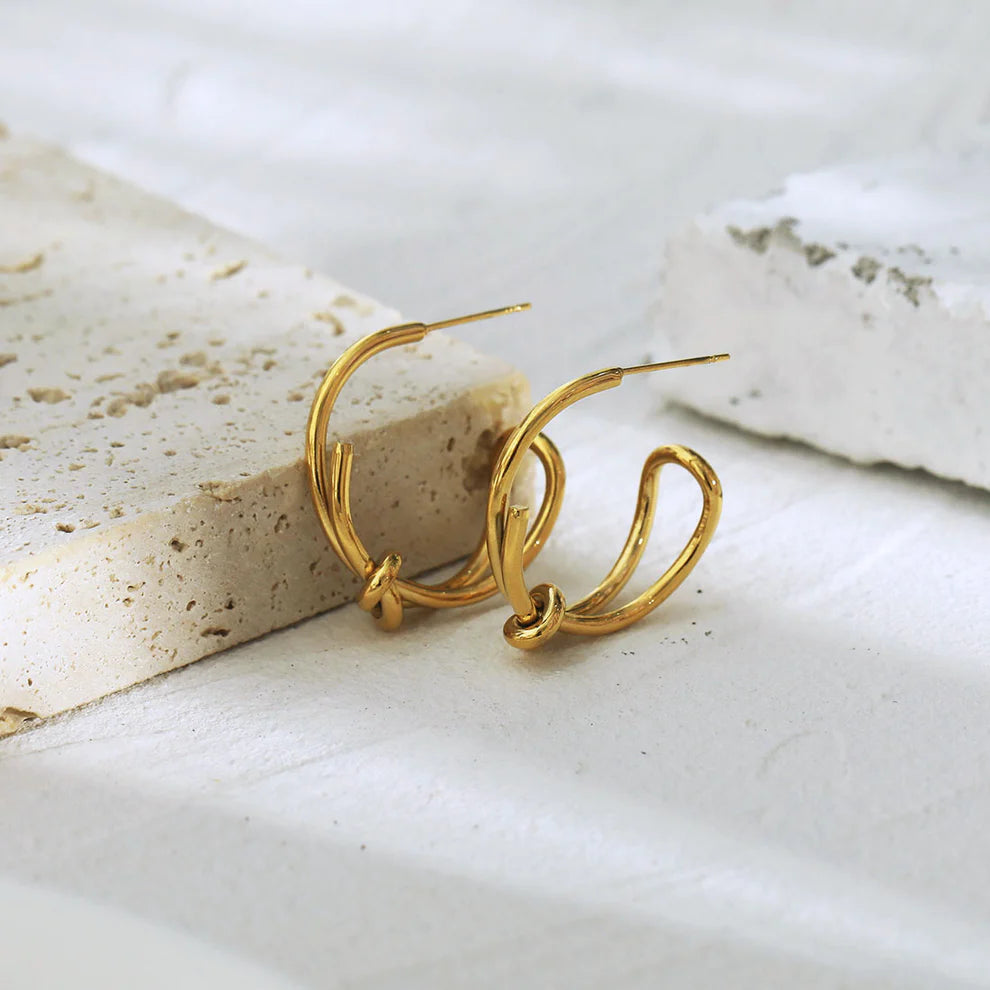 Hackney jewelry featuring a pair of abstract gold hoop earrings