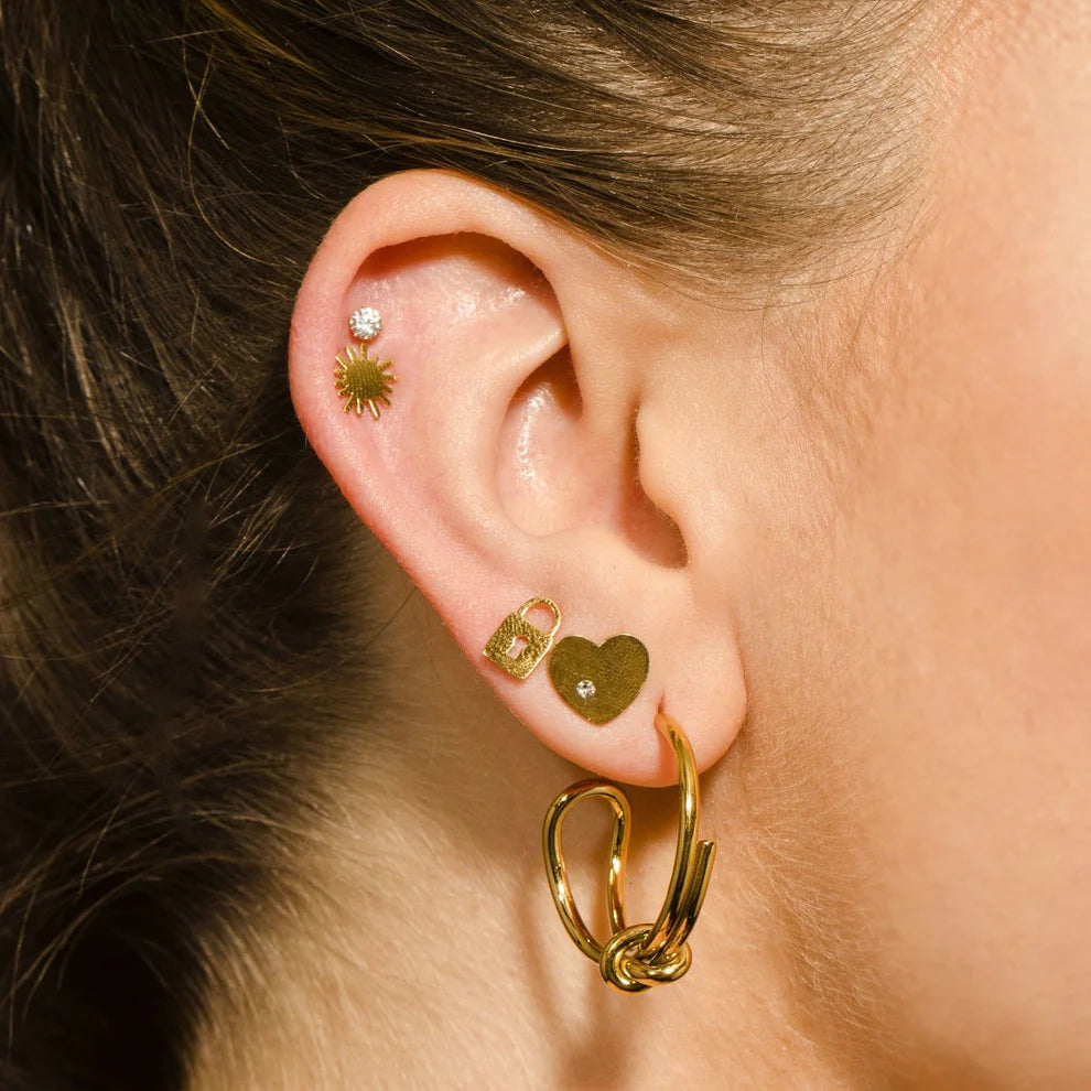 Hackney jewelry featuring a pair of abstract gold hoop earrings