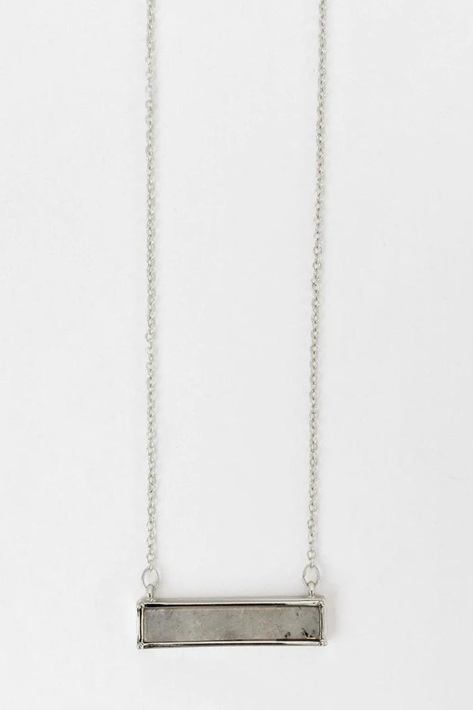 Caracol jewelry featuring a delicate chain necklace with stone pendant